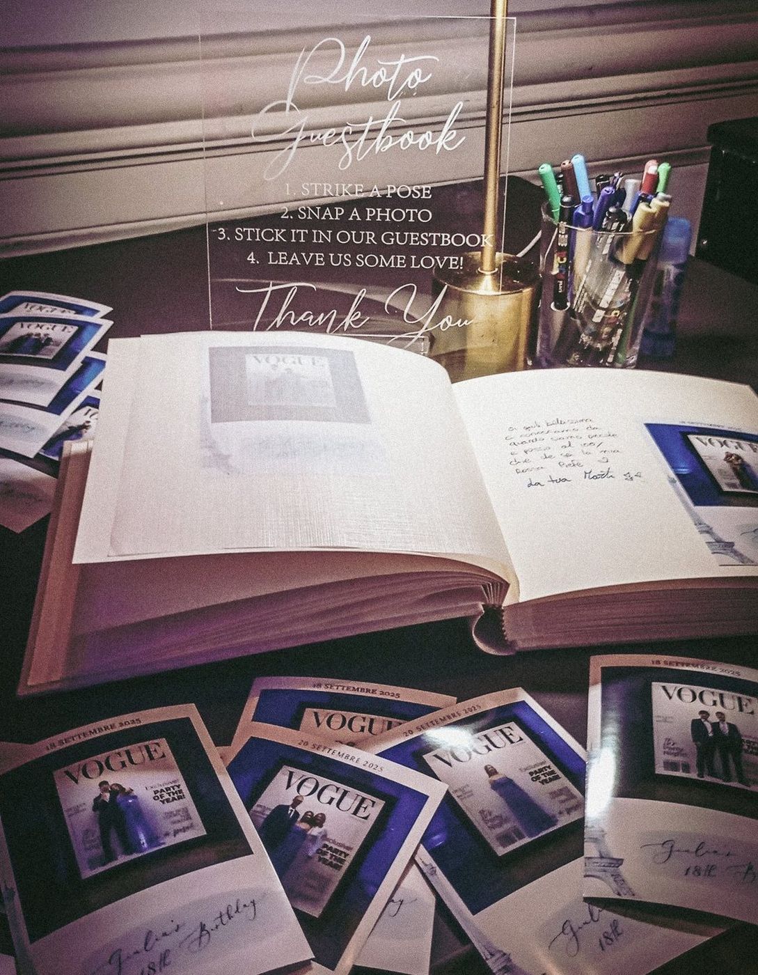 Guest book aperto con stampe fotografiche, dediche e penne